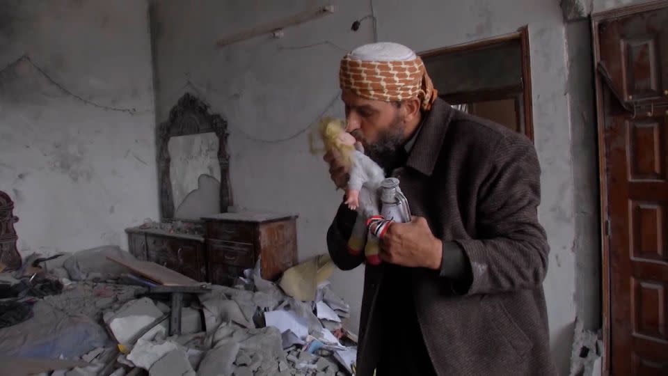 Khaled Nabhan kisses Reem's baby, who was found in the ruins of Reem's family home on November 27.  -CNN