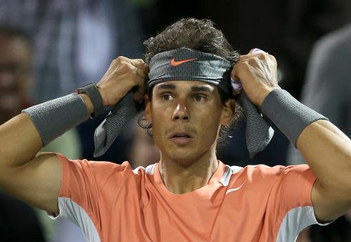 Rafael Nadal se coloca una cinta en la cabeza durante el partido de cuartos de final del torneo de tenis de Miami contra Milos Raonic el 27 de marzo de 2014 (Getty/AFP | Clive Brunskill)
