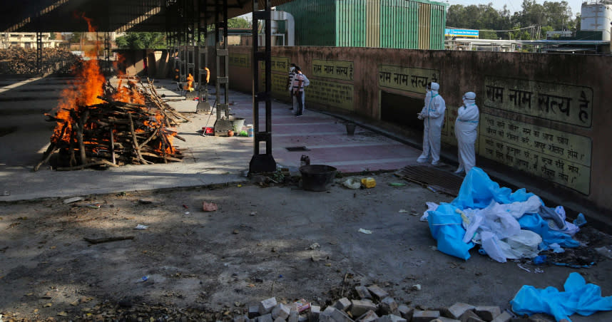 在印度查漠（Jammu）的一個火葬場，家人在為一名因新冠肺炎而死亡的人舉行最後的儀式觀看。（圖／達志／美聯社）