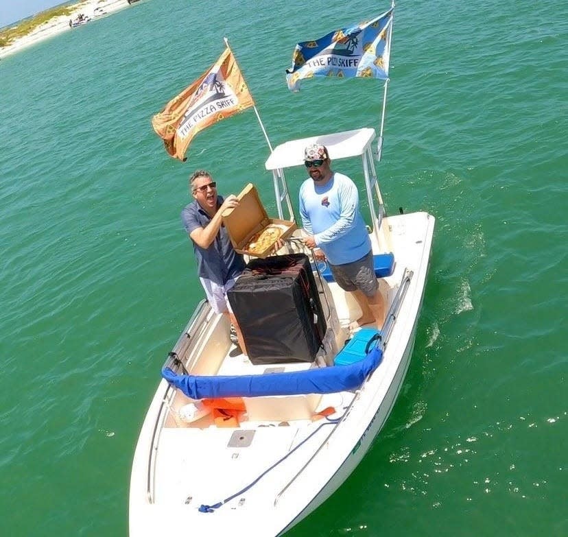 Sean Ferraro, boss of Madison Avenue Pizza, sells pizzas from his boat to swimmers.