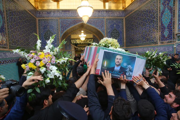 La gente transporta ataúdes durante una procesión fúnebre por el difunto presidente iraní Ebrahim Raisi