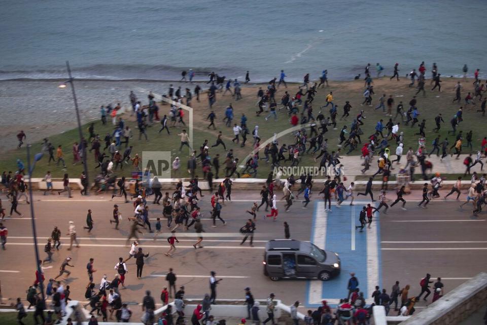 Giovani marocchini corrono mentre cercano di attraversare l'enclave spagnola di Ceuta.