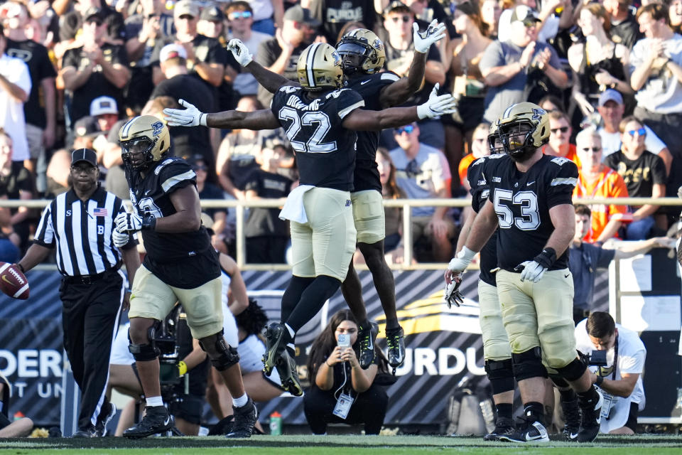 Purdue wide receiver Deion Burks (4) celebrates a touchdown with running back Dylan Downing (22) during the second half of an NCAA college football game against Illinois in West Lafayette, Ind., Saturday, Sept. 30, 2023. (AP Photo/Michael Conroy)