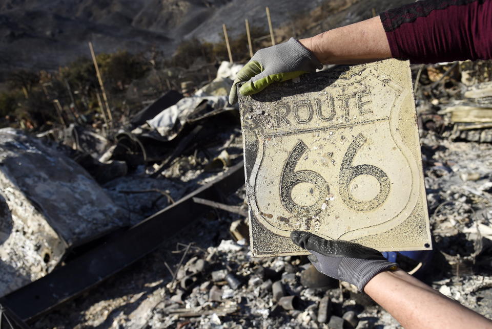 <p>Donna Phillips shows a charred Route 66 sign she found among the possessions of her friend Marsha Maus, Sunday, Nov. 11, 2018, after wildfires tore through the Seminole Springs Mobile Home Park in Agoura Hills, Calif.<br>Maus has been a resident of the neighbourhood for 15 years.<br>(Photo from Chris Pizzello, AP) </p>