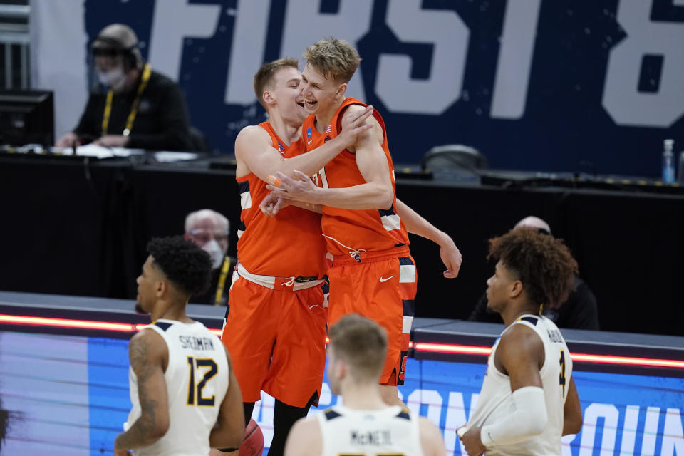 Syracuse's Buddy Boeheim (35) ad Marek Dolezaj (21) celebrate following a second-round game against West Virginia in the NCAA men's college basketball tournament at Bankers Life Fieldhouse, Sunday, March 21, 2021, in Indianapolis. Syracuse defeated Syracuse 75-72. (AP Photo/Darron Cummings)