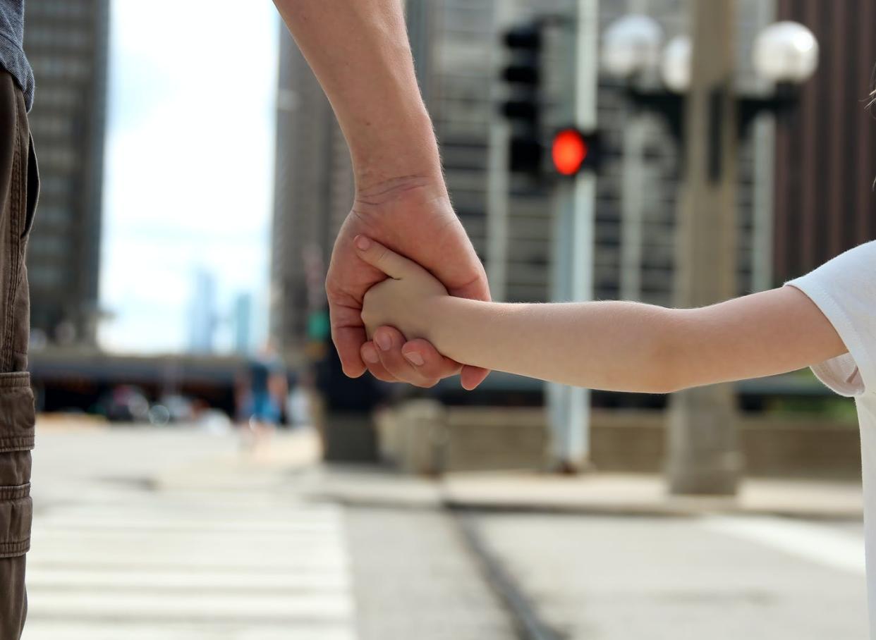 <span class="caption">An autonomous vehicle has no driver to communicate with about whether it's safe to cross.</span> <span class="attribution"><a class="link " href="https://www.gettyimages.com/detail/photo/father-holding-the-daughter-child-hand-behind-the-royalty-free-image/546425378" rel="nofollow noopener" target="_blank" data-ylk="slk:Saklakova/iStock/Getty Images Plus;elm:context_link;itc:0;sec:content-canvas">Saklakova/iStock/Getty Images Plus</a></span>