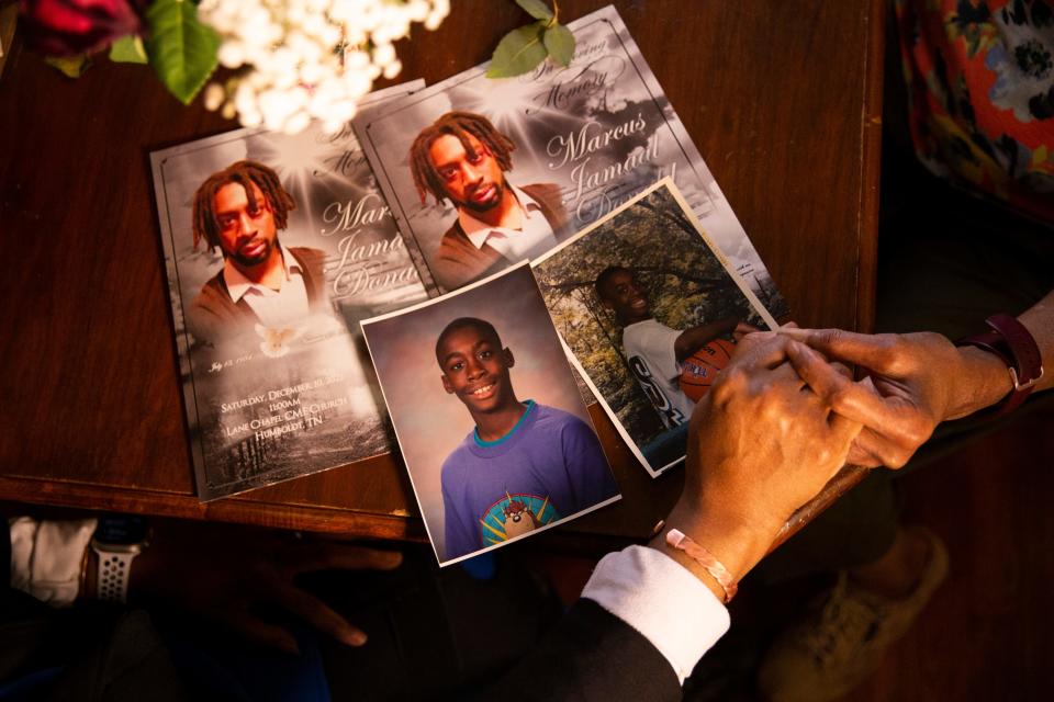 Marilyn Donald and Elvis Ellis, the mother and grandmother of Marcus Donald, hold hands and look at family photos of Marcus as a child and teenager along with the program from his funeral in Ellis’ home in Memphis on March 20, 2023.