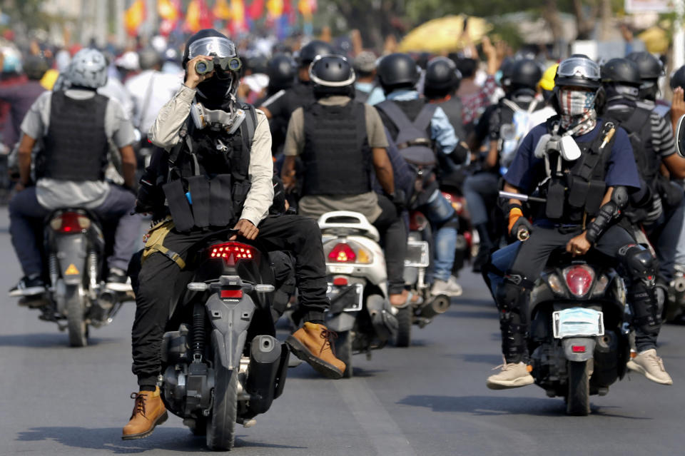 A man uses binoculars as they ride on motorcycles during an anti-coup protest in Mandalay, Myanmar on Thursday March 25, 2021. Protesters against last month's military takeover in Myanmar returned to the streets in large numbers Thursday, a day after staging a "silence strike" in which people were urged to stay home and businesses to close for the day. (AP Photo)