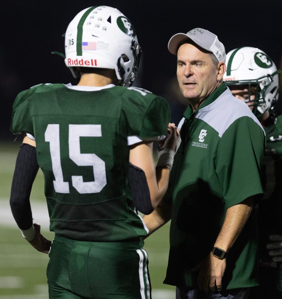 Central Catholic football coach Jeff Lindesmith talks with receiver Braylywn Tabellion on the sidelines Sept. 29 against Mogadore.