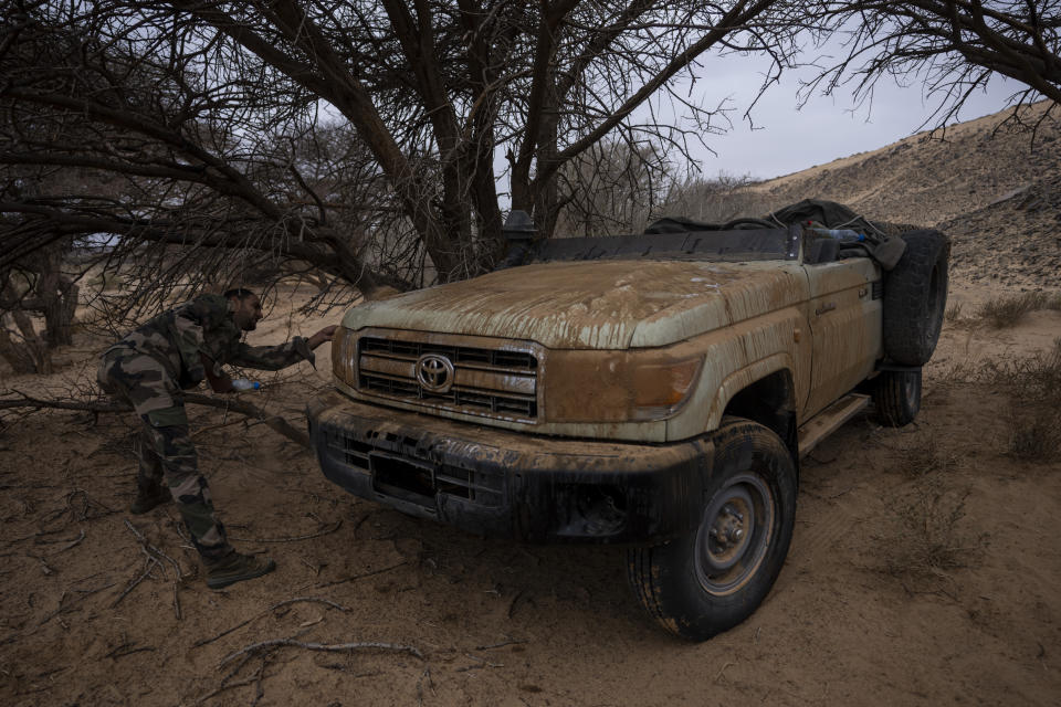 A soldier from the Polisario Front camouflages a vehicle, near Mehaires, Western Sahara, Thursday, Oct. 14, 2021. (AP Photo/Bernat Armangue)