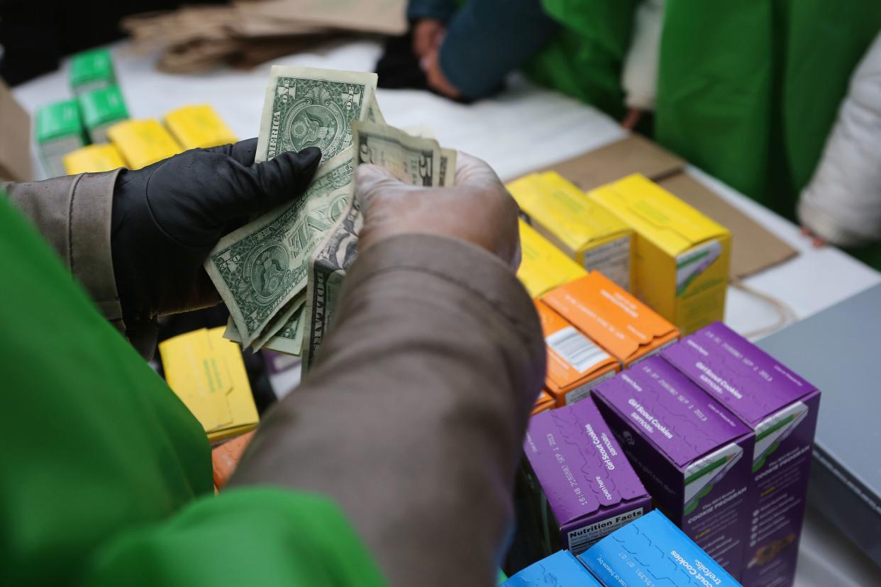 Money is collected as Girl Scouts sell cookies while a winter storm moves in on February 8, 2013 in New York City.