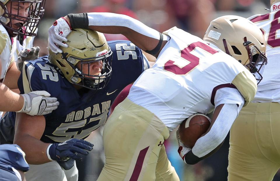 Hoban defensive lineman Jason Martin III wraps up Iona Prep running back Colin O'Garro at the line of scrimmage during the first half, Saturday, Sept. 3, 2022.