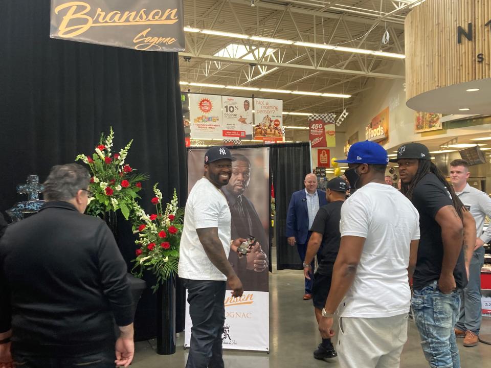 Rapper 50 Cent smiles at fans during his meet-and-greet Sunday at the Prairie Trail Hy-Vee in Ankeny, Iowa. Fans started lining up about11 a.m. for the event, sponsored by Sire Spirits, which makes Branson Cognac and Le Chemin Du Roi Champagne. Customers who bought Sire Spirits products Sunday had the chance to meet 50 Cent, take pictures and have him sign their bottles.