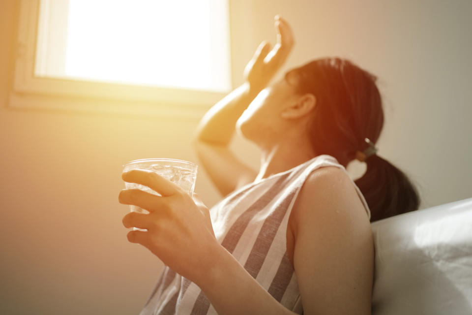 A woman tries to block the sunlight with her hand