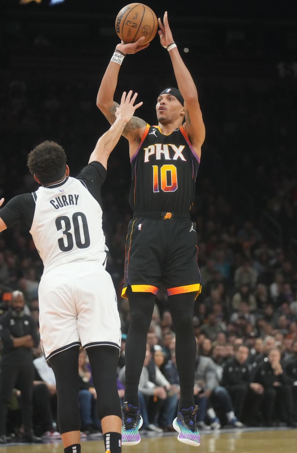 Phoenix Suns guard Damion Lee (10) shoots the ball over Brooklyn Nets guard Seth Curry (30) at Footprint Center on Jan. 19, 2023.