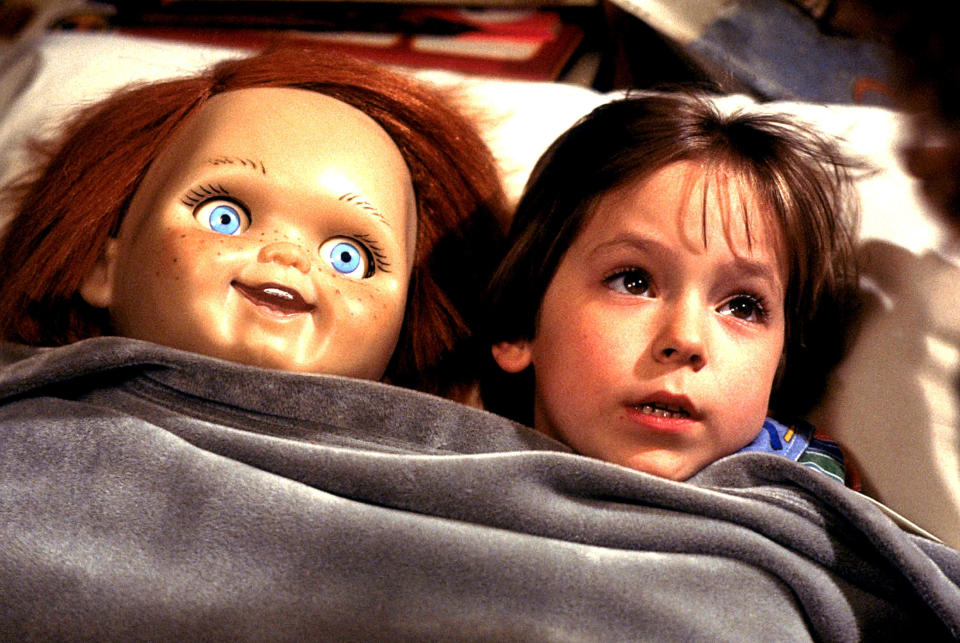 closeup of a child sleeping with a chucky doll