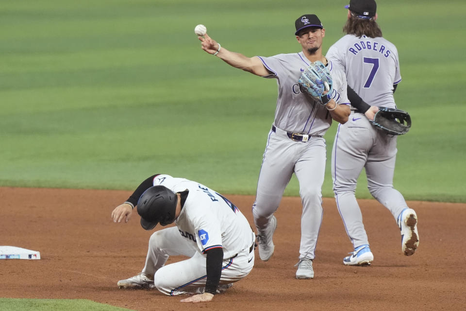 Miami Marlins' Nick Fortes (4) is out as Colorado Rockies shortstop Ezequiel Tovar throws to first base to complete the double play during the fourth inning of a baseball game, Thursday, May 2, 2024, in Miami. (AP Photo/Marta Lavandier)