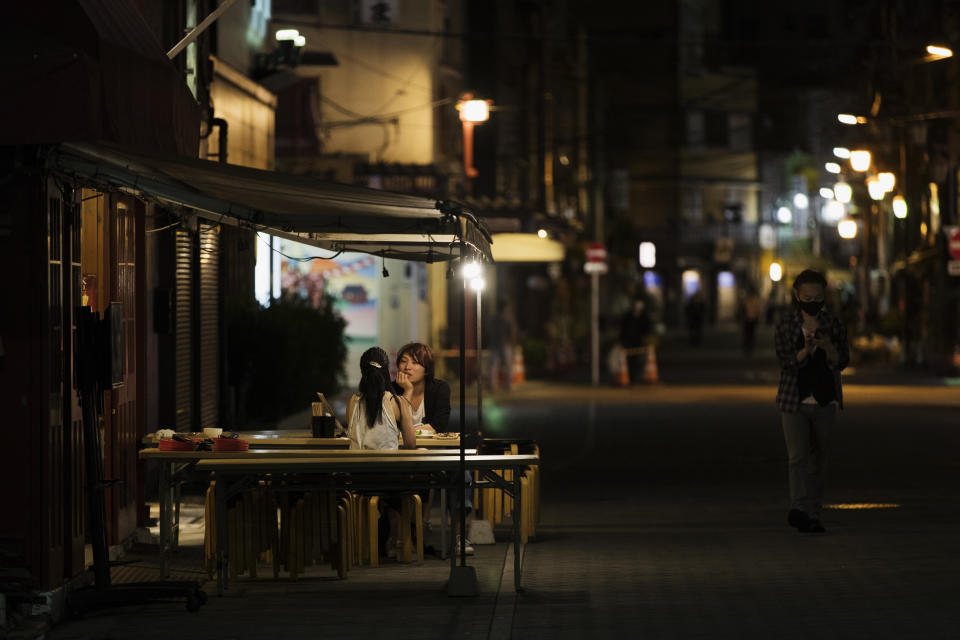 A man and a woman talk over food and drinks at a restaurant in the famed Asakusa tourist spot in Tokyo after 8 p.m., the time the government suggested to close under the ongoing state of emergency on Thursday, Sept. 30, 2021. On Friday, Oct. 1, 2021, Japan fully came out of a coronavirus state of emergency for the first time in more than six months as the country starts gradually easing virus measures to help rejuvenate the pandemic-hit economy as the infections slowed.(AP Photo/Hiro Komae)