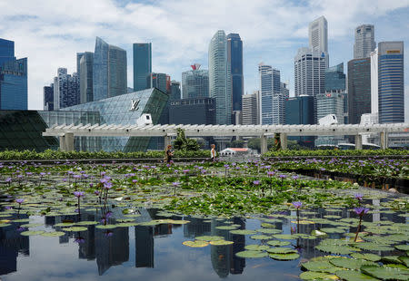 FILE PHOTO: People pass the skyline of Singapore October 11, 2017. REUTERS/Edgar Su/File Photo