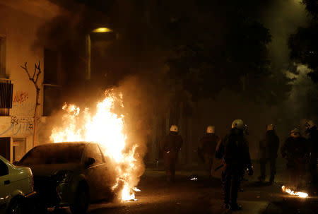 A car is seen on fire next to riot police during clashes following an anniversary rally marking the 2008 police shooting of 15-year-old student, Alexandros Grigoropoulos, in Athens, Greece, December 6, 2017. REUTERS/Alkis Konstantinidis