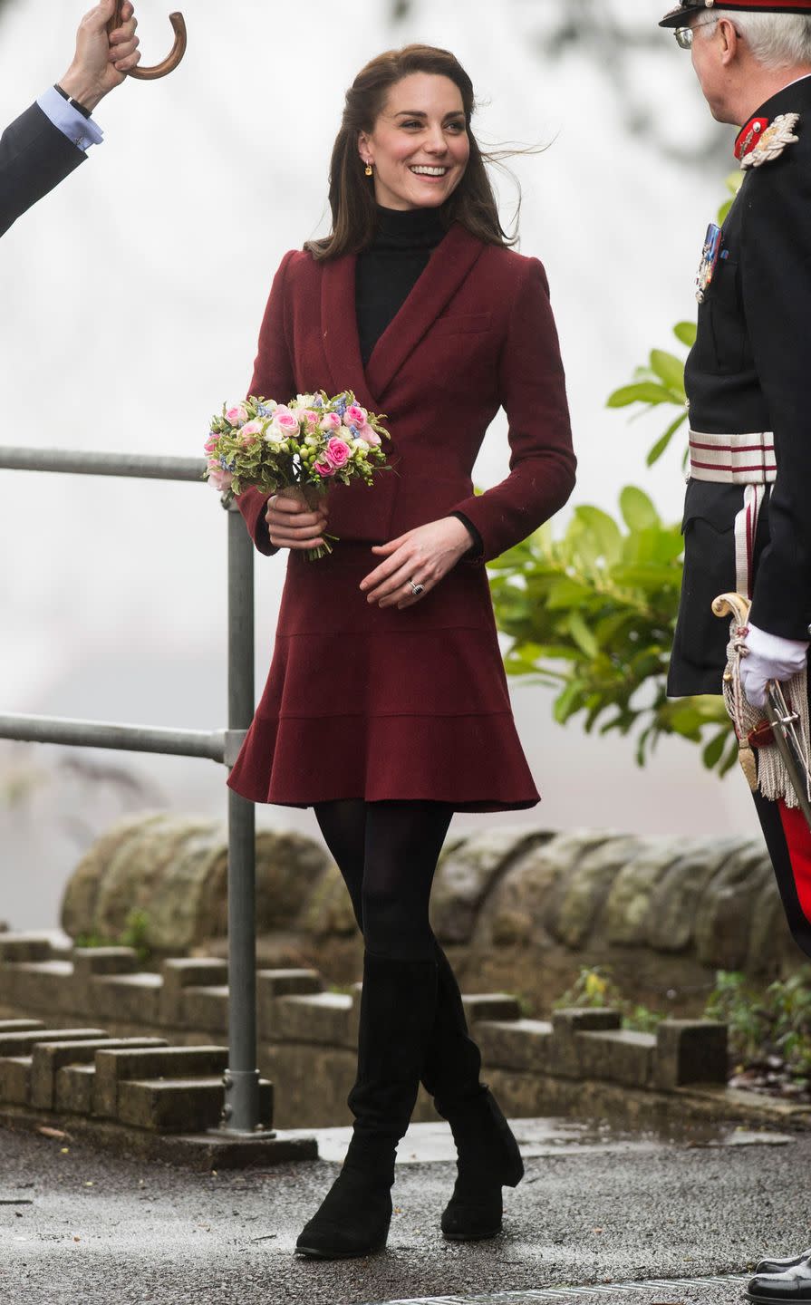 <p>The Duchess of Cambridge wears a burgundy Paule Ka skirt suit, black tights, and black knee-high <span>Stuart Weitzman</span> boots during a visit to Wales.</p>