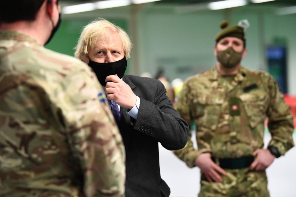 Britain's Prime Minister Boris Johnson meets troops as they set up a vaccination centre in the Castlemilk district in Glasgow, Scotland on January 28, 2021, during a COVID-19 related visit to the country. - Prime Minister Boris Johnson headed to Scotland on Thursday to praise the United Kingdom's collective response to coronavirus, in a bid to counter record support for independence. (Photo by Jeff J Mitchell / POOL / AFP) (Photo by JEFF J MITCHELL/POOL/AFP via Getty Images)