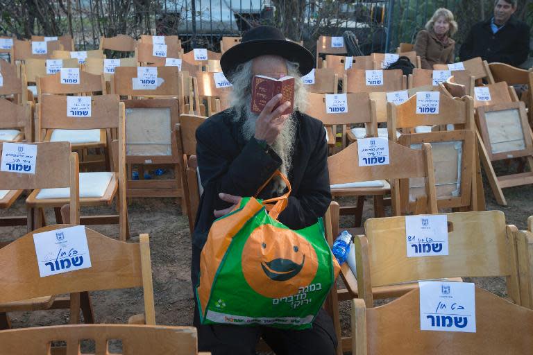 A Jewish Orthodox man prays at the grave of former Israeli prime minister Ariel Sharon's where he was buried at the family ranch in the southern Negev desert, on January 13, 2014