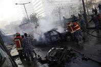 Civil Defence personnel extinguish fires on cars at the site of an explosion in Beirut downtown area December 27, 2013. Former Lebanese minister Mohammed Shattah was killed in the explosion that targeted his convoy in Beirut on Friday, three security sources told Reuters. REUTERS/Steve Crisp