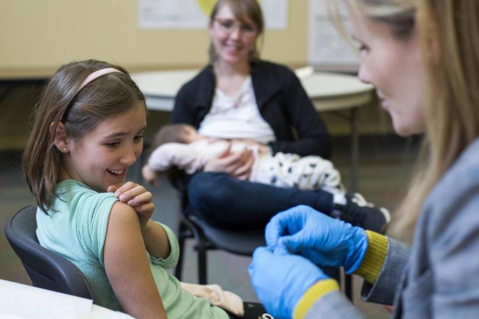 A 9-year-old rolls up her sleeve for a vaccination at a clinic in Portland, Oregon, on Feb. 16, 2019. Measles was declared eliminated in the United States in 2000, but scattered outbreaks have occurred in recent years, including a recent case in Broward.
