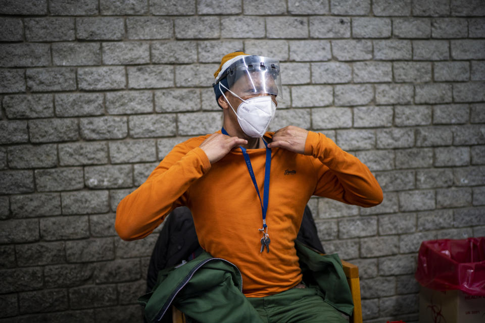 A factory worker waits to be vaccinated by medical workers who travelled on a COVID-19 vaccine train parked at the Swartkops railroad yard outside Gqeberha, South Africa, as part of an outreach program Thursday Sept. 23, 2021. South Africa has sent a train carrying COVID-19 vaccines into one of its poorest provinces to get doses to areas where healthcare facilities are stretched. The vaccine train, named Transvaco, will go on a three-month tour through the Eastern Cape province and stop at seven stations for two weeks at a time to vaccinate people. (AP Photo/Jerome Delay)