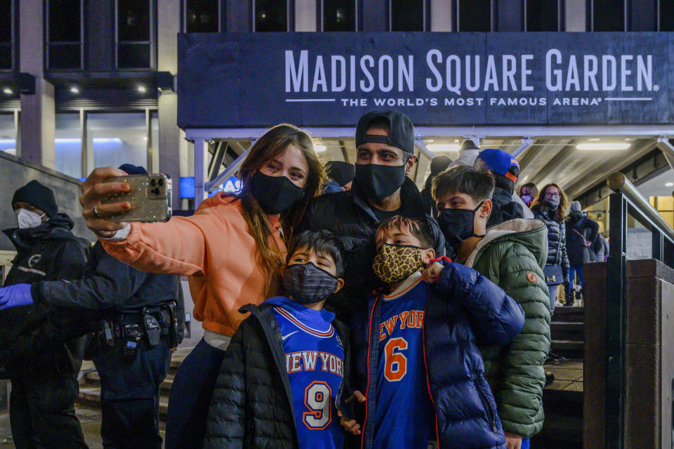 The Quershif family take a selfie outside Madison Square Garden before an NBA basketball game between the New York Knicks and the Golden State Warriors in New York on Tuesday, Feb. 23, 2021. A limited number of fans was allowed to attend. (AP Photo/Brittainy Newman)