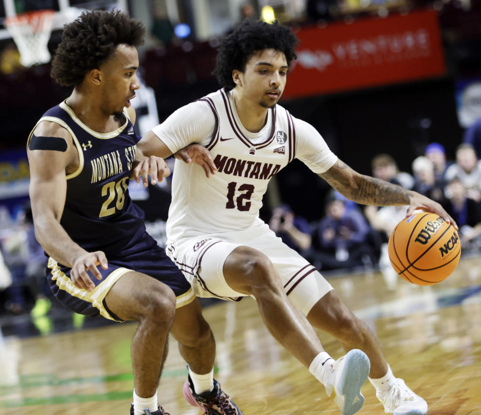 Montana guard Brandon Whitney (12) drives against Montana State guard Robert Ford III (20) during the first half of an NCAA college basketball game for the Big Sky men's tournament championship Wednesday, March 13, 2024, in Boise, Idaho. (AP Photo/Kyle Green)