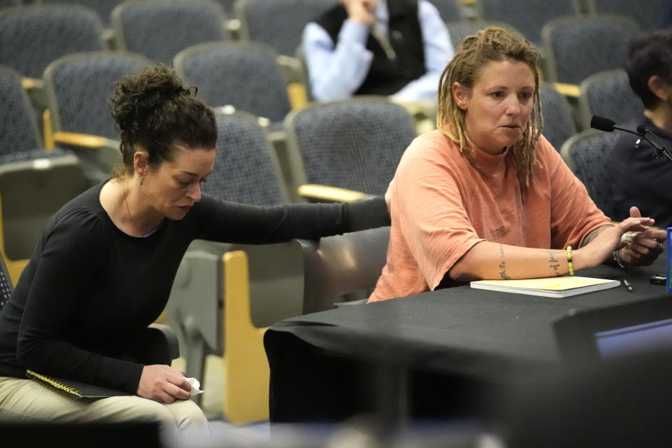 Cara Lamb, ex-wife of shooter Robert Card, is comforted as she testifies, Thursday, May 16, 2024, in Augusta, Maine, during a hearing of the independent commission investigating the law enforcement response to the mass shooting in Lewiston, Maine. (AP Photo/Robert F. Bukaty)