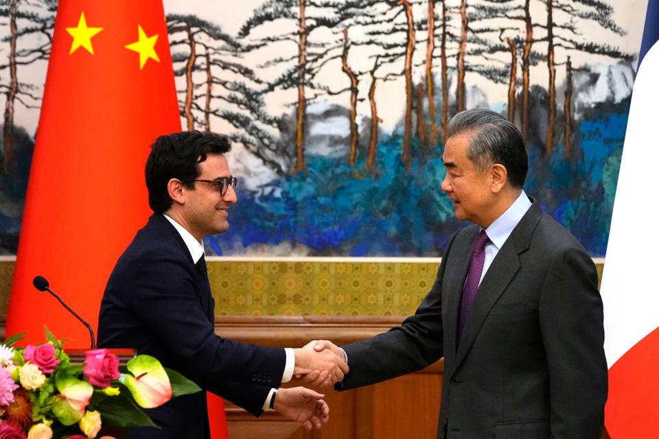 Chinese Foreign Minister Wang Yi (right) shakes hands with French Foreign Minister Stephane Sejourne after a joint press conference at the Diaoyutai State Guesthouse in Beijing, China, on Monday (AP)