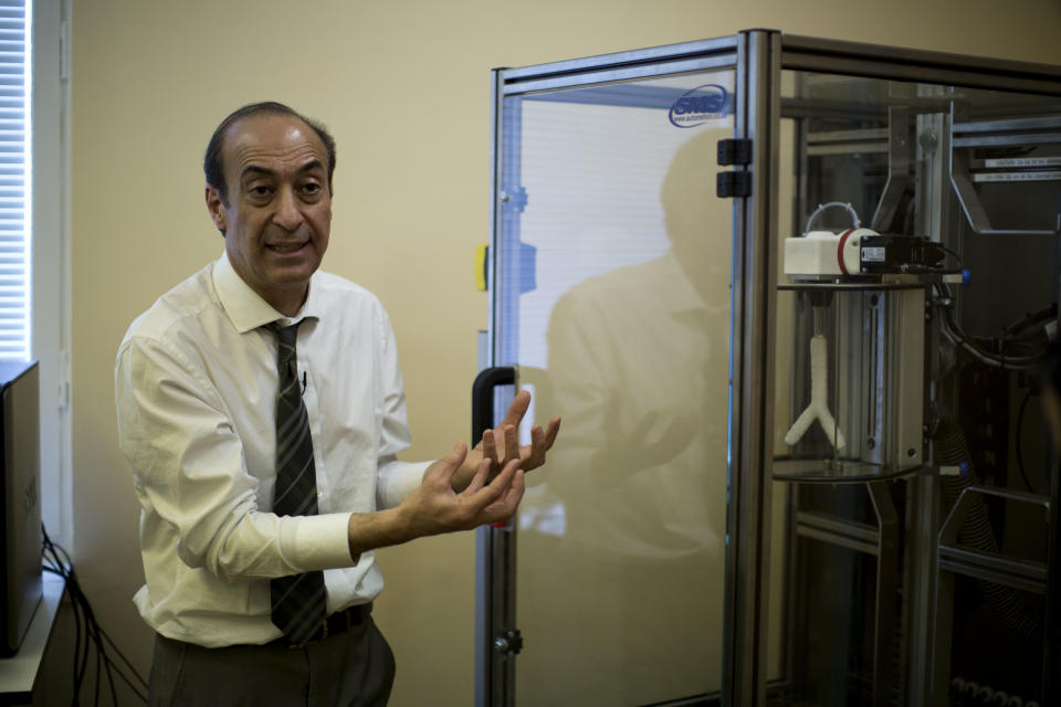 Professor Alexander Seifalian speaks next to an automated dip coating machine with a synthetic mould of a windpipe inside at his research facility in the Royal Free Hospital in London, Monday, March 31, 2014. In a north London hospital, scientists are growing noses, ears and blood vessels in the laboratory in a bold attempt to make body parts using stem cells. It is among several labs around the world, including in the U.S., that are working on the futuristic idea of growing custom-made organs in the lab. While only a handful of patients have received the British lab-made organs so far— including tear ducts, blood vessels and windpipes — researchers hope they will soon be able to transplant more types of body parts into patients, including what would be the world's first nose made partly from stem cells. "It's like making a cake," said Alexander Seifalian at University College London, the scientist leading the effort. "We just use a different kind of oven." (AP Photo/Matt Dunham)