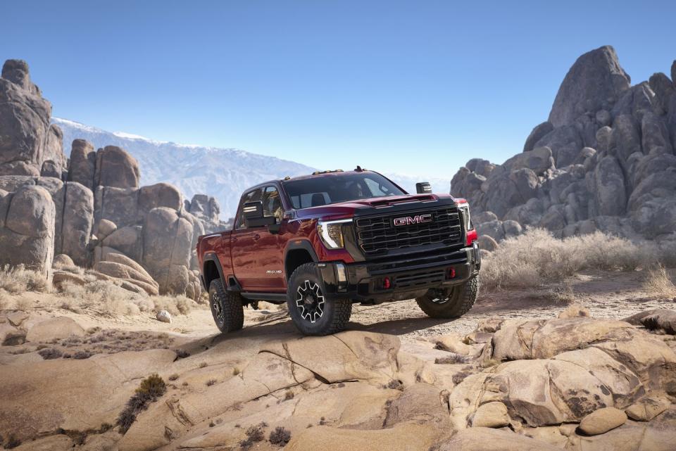 2024 gmc sierra 2500hd at4x in volcanic red tintcoat tackling rocky off road conditions