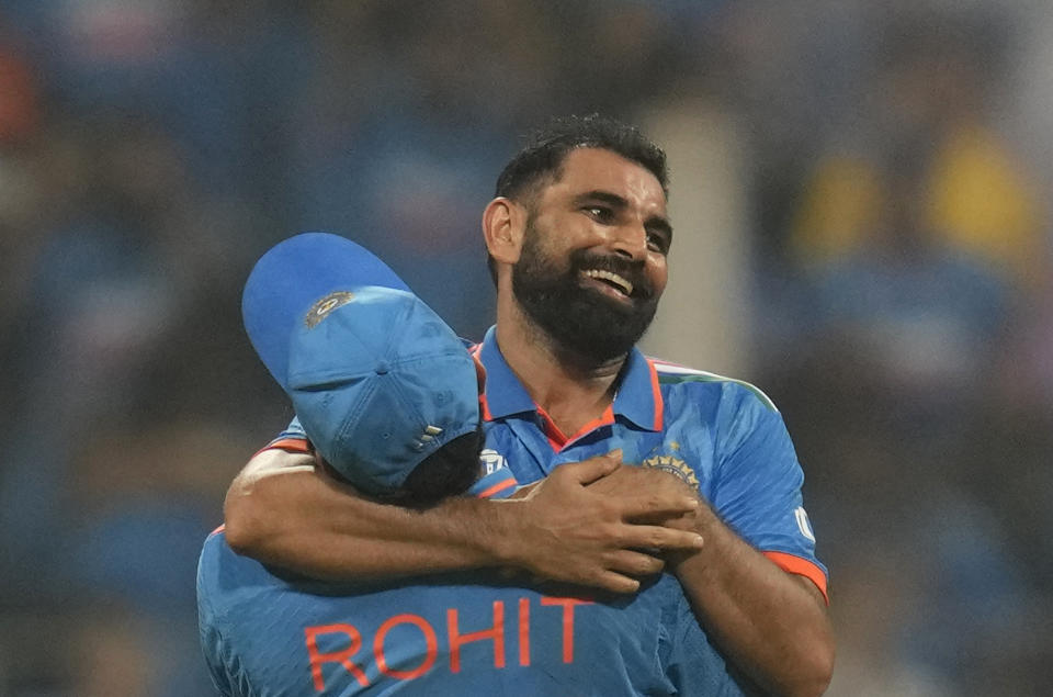 India's captain Rohit Sharma lifts Mohammed Shami after he took the last wicket and overall seven wickets to beat New Zealand by 70 runs during the ICC Men's Cricket World Cup first semifinal match in Mumbai, India, Wednesday, Nov. 15, 2023. (AP Photo/Rafiq Maqbool)