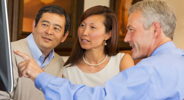 Couple looking at computer with their financial adviser