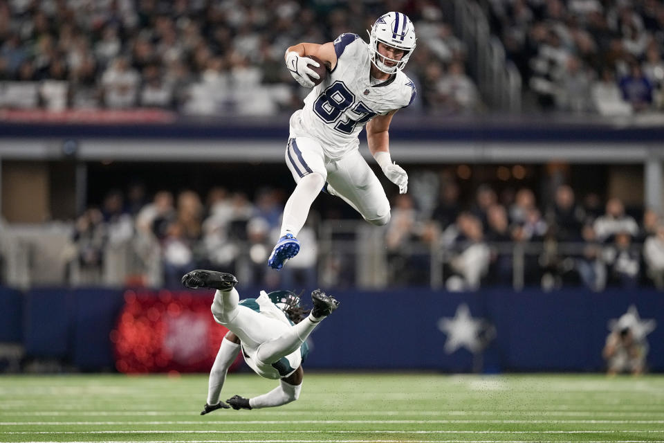 Dallas Cowboys tight end Jake Ferguson (87) leaps over the tackle attempt of Philadelphia Eagles cornerback Kelee Ringo (22) during the second half of an NFL football game, Sunday, Dec. 10, 2023, in Arlington, Texas. (AP Photo/Sam Hodde)