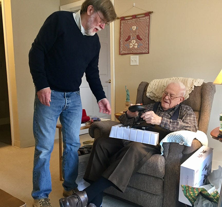 Centenarian John Robinson and the author, his son J. Dennis Robinson, discuss the workings of a new radio-controlled drone.