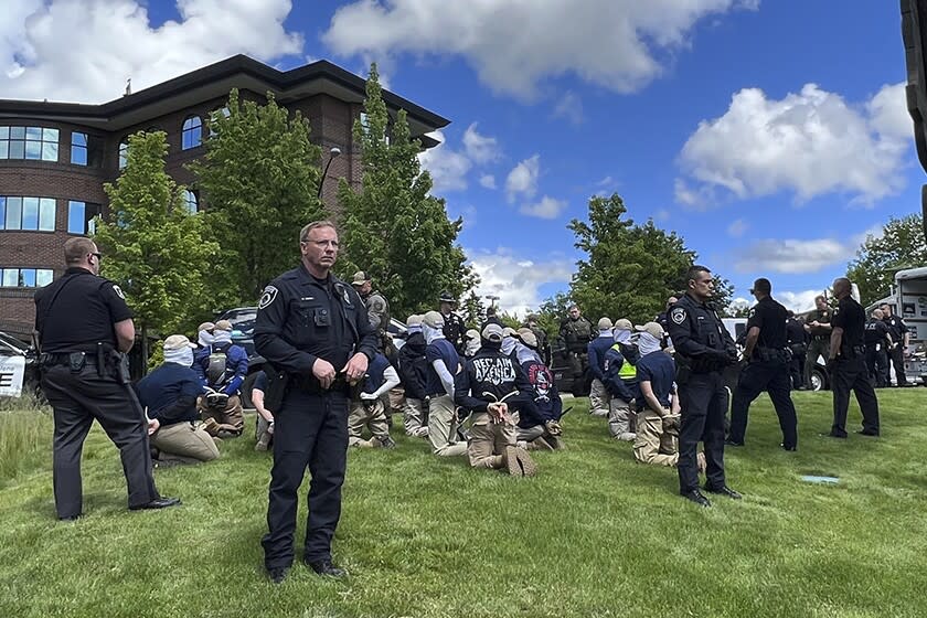 Police guard members of a white supremacist group after their arrests Saturday in Coeur d'Alene, Idaho.