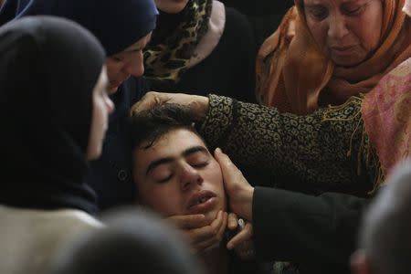 A relative of Palestinian minister Ziad Abu Ein is comforted during his funeral in the West Bank city of Ramallah December 11, 2014. REUTERS/Mohamad Torokman