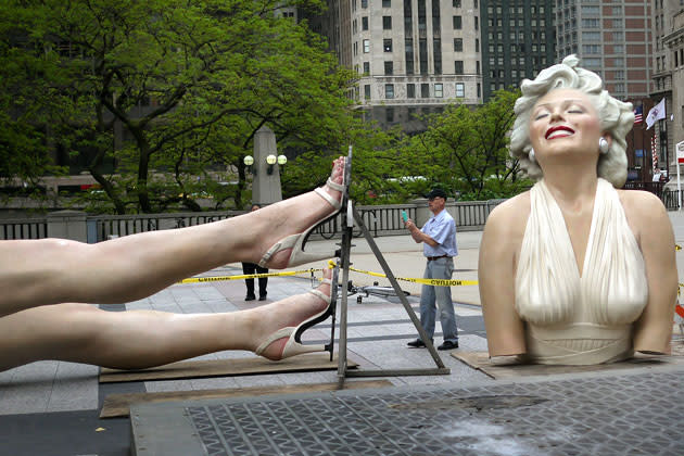 A passerby photographs one of the dismantled pieces of 'Forever Marilyn', a sculpture by Seward Johnson, as it is prepared for removal from Pioneer Court May 8, 2012 in Chicago, Illinois. The stainless steel and aluminum sculpture, which stands 26 feet tall and weighs 34,000 pounds, was inspired by Marilyn Monroe?s iconic scene in the 1955 movie 'The Seven Year Itch'. The sculpture, which has been on display in Chicago since last July, will next be displayed in Palm Springs, California. (Photo by Scott Olson/Getty Images)