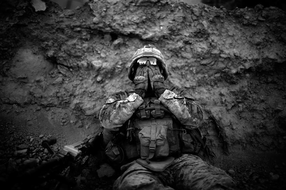 Marine Lance Cpl. Anthony Espinoza wipes the sweat out of his eyes at the end of a daylong patrol of the Sangin District in southern Afghanistan in May 2011.