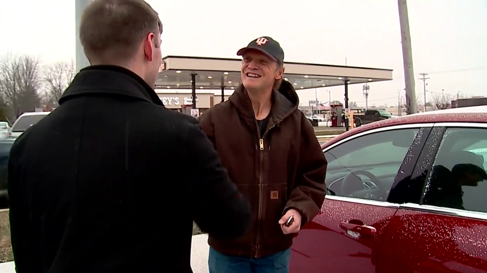 Pizza deliveryman Robert Peters, right, receives a red Chevy Malibu from customer Tanner Langley.  / Credit: CBS News