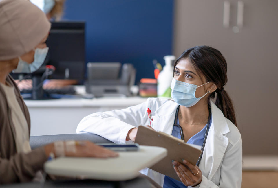 a female doctor talking to a patient with a clipboard