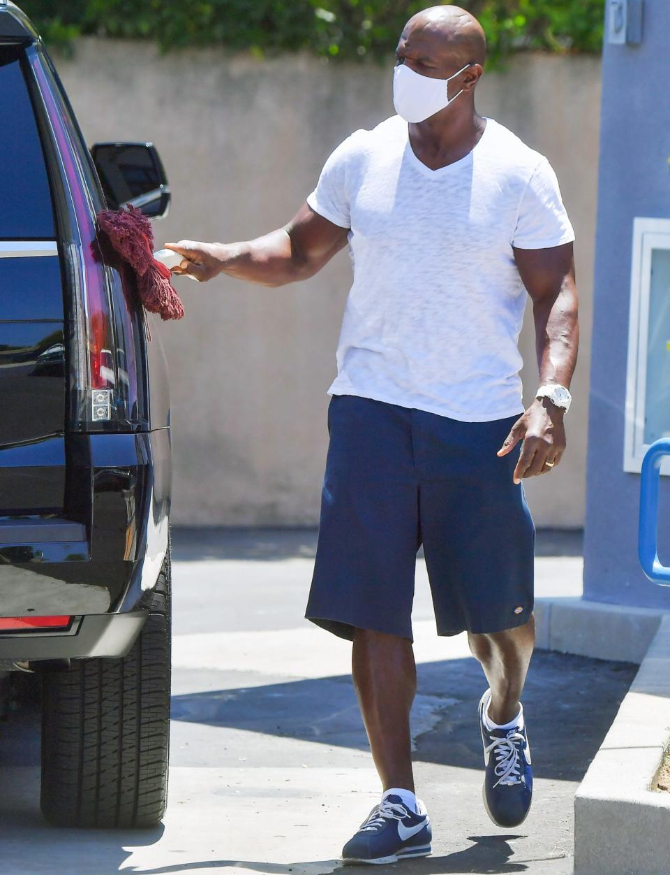 <p>Terry Crews dusts off his black Escalade while filling his tank at his local gas station in L.A. on Wednesday.</p>