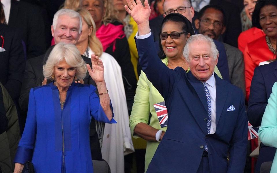 King Charles Queen Camilla wave at the crowds as they arrive for the Coronation Concert at Windsor Castle - AFP