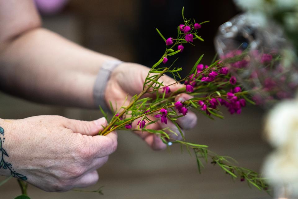 Jenn Drake creates bouquets for Mother's Day in her flower shop.