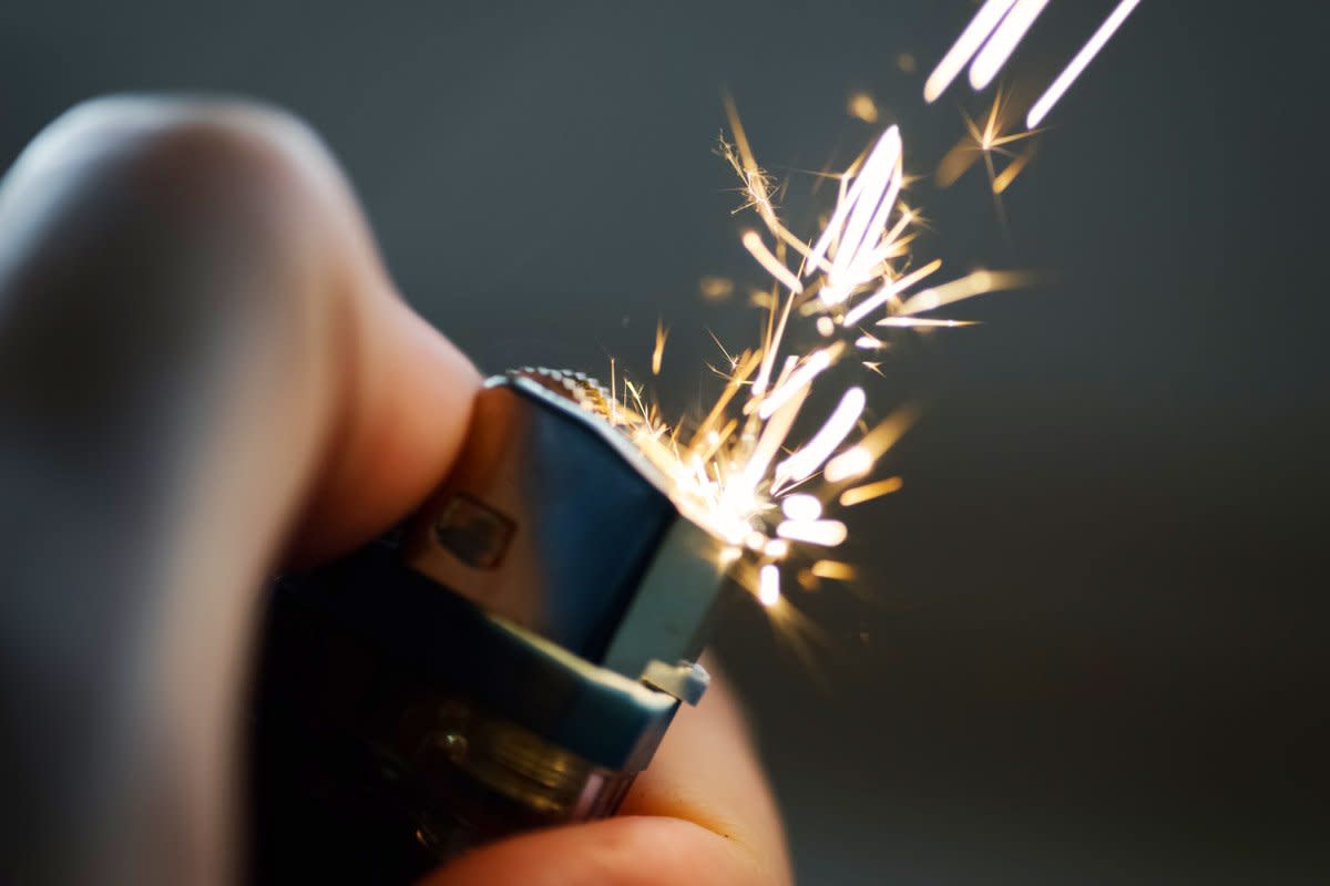A person uses a lighter. 